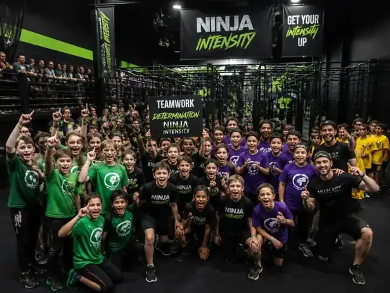 Grupa dzieci i trenerów podczas eventu na torze ninja